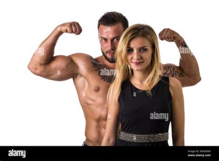 a man and woman posing for a photo in a kitchen with blue