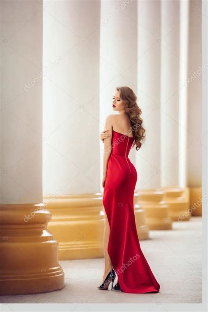 a woman in a red shirt is looking at the camera with an intense look on