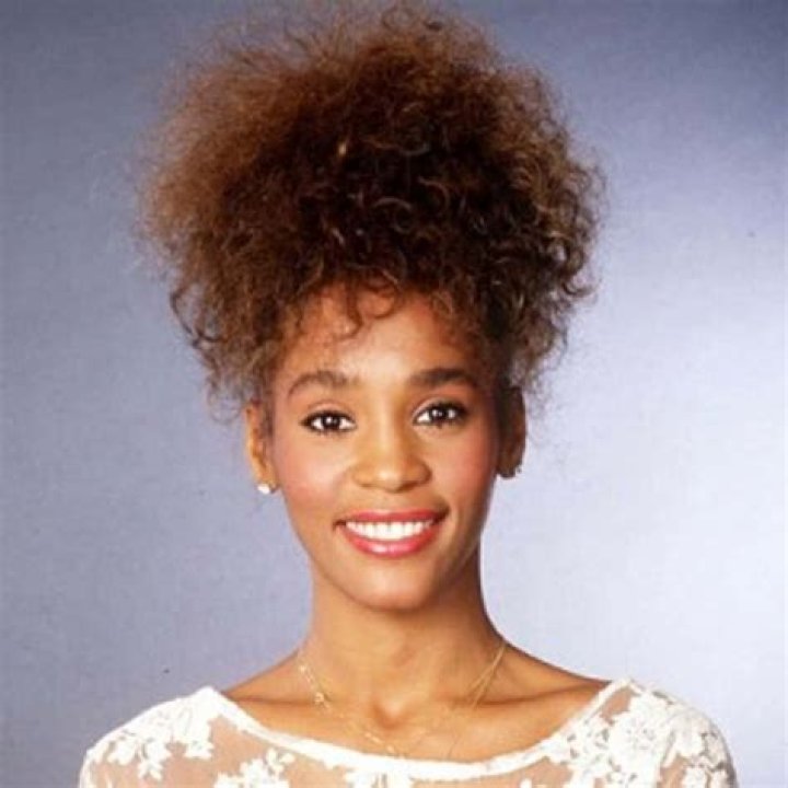 A Young Whitney Houston poses with her mother Cissy Houston , father