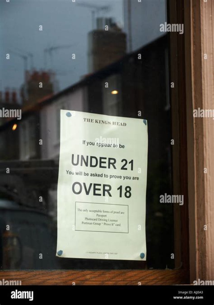 Alcohol consumption legal age sign posted in pub window near Earls