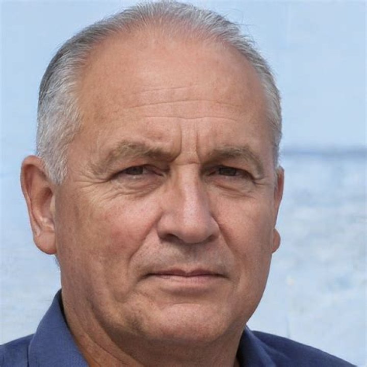 an older man in a suit and tie looking off to the side with his eyes