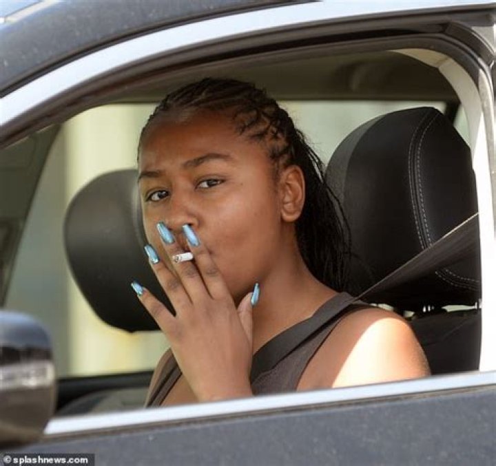 Sasha Obama puffs on a cigarette and shows off VERY long talons as she