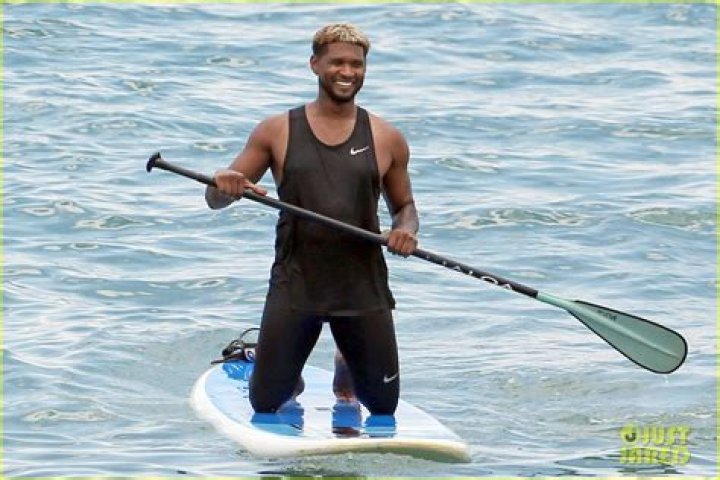 Usher Stays Clothed While Paddle Boarding, Goes Shirtless on the Beach